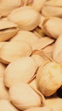 Tuzlu şam fıstıklı bira aperatifi daire şeklinde döner. Sağlıklı, lezzetli fıstıklar. Dikey video.