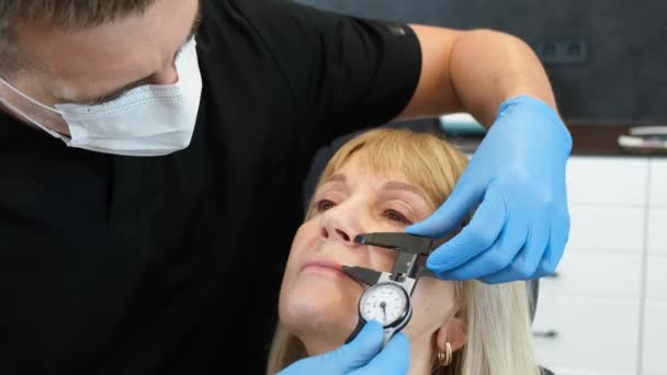 Seorang Dokter Mempersiapkan Seorang Wanita Tua Untuk Operasi Plastik Wajahnya — Stok Video