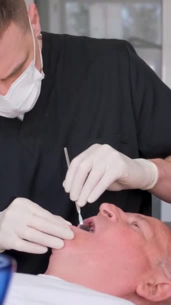 Dentista Masculino Trabaja Con Anciano Examinando Sus Dientes Clínica Concepto — Vídeo de stock