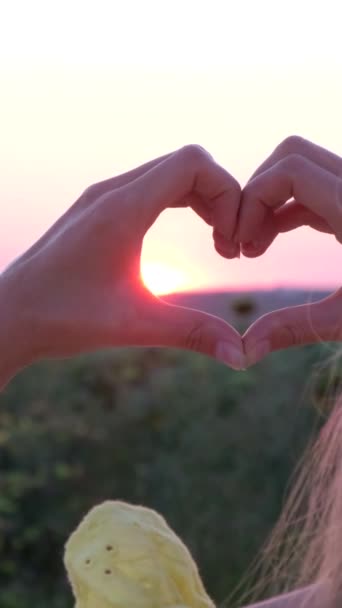 Młoda Kobieta Robi Gest Serca Dłońmi Przy Pięknym Zachodzie Słońca — Wideo stockowe