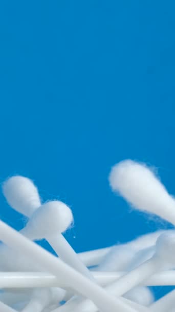 美しい青い背景にコットンの耳の芽の混沌とした山が円で回転します ボディ衛生製品の主題ビデオ撮影 バーティカルビデオ — ストック動画