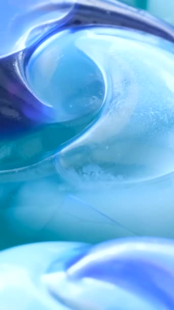 一组蓝色洗衣粉盘旋转成圆圈的放大图像 在洗衣机里进行高质量洗涤的方法 垂直录像 — 图库视频影像