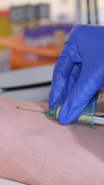 一名女医生向一名病人注射注射器进行血液取样的特写 护士在实验室采集病人的血样 垂直录像 — 图库视频影像