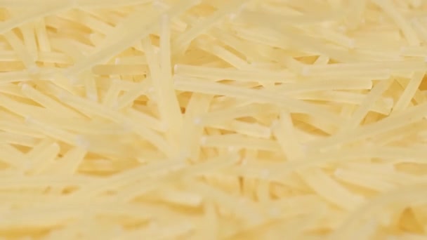 インスタント麺は円で回転します 原生マカロニのトップビュー 生パスタの束を閉じる バーティカルビデオ — ストック動画