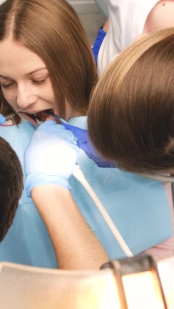 Dwóch Lekarzy Maskach Ochronnych Klinice Dentystycznej Obsługujących Pacjentkę Koncepcja Opieki — Wideo stockowe