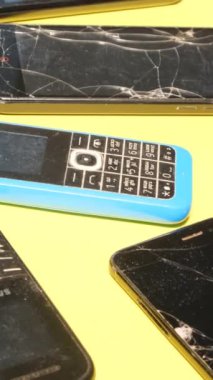 Kırık ekranlı çatlak cep telefonları. Cep telefonlarının geri dönüşümü. Zararlı atık. E-atığı geri dönüştür. Dikey video