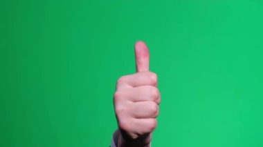 Yeşil arka planda baş parmak hareketini göster. Erkek el uzanıyor ve başparmak kaldırıyor, anahtarlı yeşil ekran. Dikey video