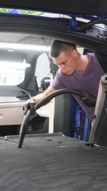 Temizlik merkezinin bir çalışanı bir arabayı temizliyor. Kirden arabanın profesyonel temizliği. Dikey video