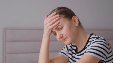 Zavallı, üzgün, depresif genç bir kadının yakın çekimi. Kafası aşağıda ve elleri yüzünün önünde sıkıca bağlanmış bir kadın. Dikey video