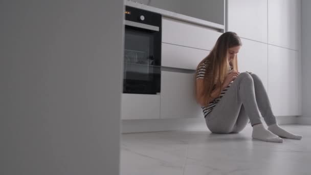 悲しい心配の女性の不安やうつ病の症状を感じ 不満のトラブルについて考えながら キッチンに座っている 精神衛生 — ストック動画