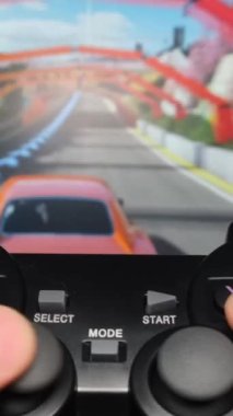 Genç bir adam makinelerde bilgisayar oyunu oynuyor, oynamak için joystick kullanıyor. Boş zaman. Bilgisayar oynatıcı