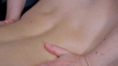 Sırt masajı aynı anda dört elle yapılır. İki profesyonel masaj terapisti hastayla ilgilenir. Sağlık hizmetleri. Dikey video