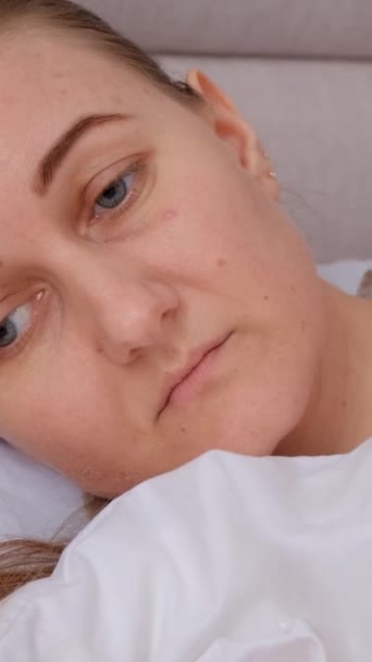 落ち込んだ悲しい若い女性がベッドに横たわり 思い出し 家庭の寝室で病気を感じ 病気やうつ病に苦しんでいる バーティカルビデオ — ストック動画