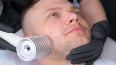 RF ultrason kullanılarak erkek yüzü gençleştirme prosedürü. Yüzün yaşlanmasına karşı estetik prosedürler. Güzellik salonu. Dikey video