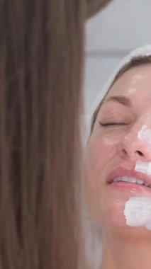 Spa yüz maskesi uygulaması. Spa güzelliği organik yüz maskesi uygulaması. Dikey video