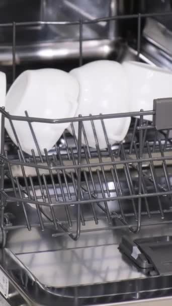 食器洗い機からの皿の荷を下すこと 洗練された光沢のある食器洗い機 バーティカルビデオ — ストック動画
