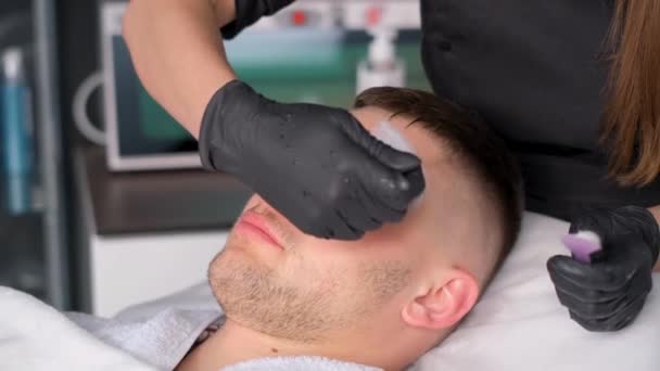 Aproape Bărbat Atractiv Culcat Relaxat Spa Cosmetician Aplică Crema Față — Videoclip de stoc