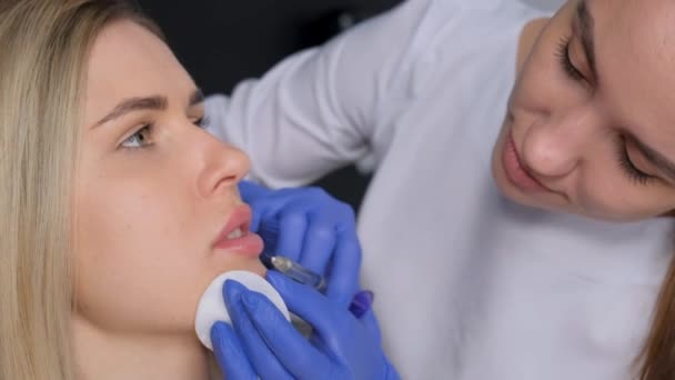 Seorang Ahli Bedah Yang Mengenakan Sarung Tangan Medis Menusuk Bibir — Stok Video