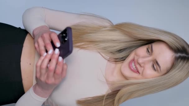 Красивая Блондинка Красивыми Длинными Волосами Читает Сообщение Смартфоне Портрет Профессиональной — стоковое видео