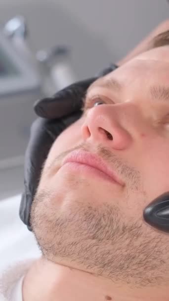얼굴을 초음파 장치에 남성의 여드름의 남자는 스파에서 리프팅 마사지를받습니다 비디오 — 비디오