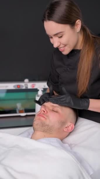 Homem Deitado Uma Cama Spa Recebe Uma Massagem Facial Pele — Vídeo de Stock