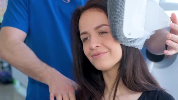 一个年轻的女孩在现代医疗技术机器上做运动 检查病人的脊椎专家的工作 预防脊柱疾病 垂直录像 — 图库视频影像