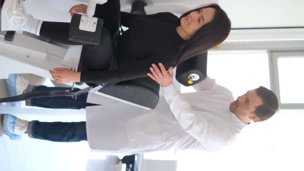 在现代技术机器上对病人进行检查的脊椎专家的垂直录像 预防脊柱疾病 垂直录像 — 图库视频影像