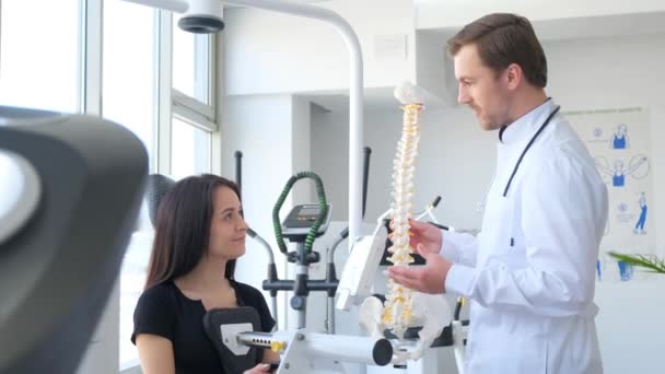 预防脊柱疾病 一个年轻的女人用医生的诊断仪器检查脊柱 脊椎专家的专业工作 — 图库视频影像