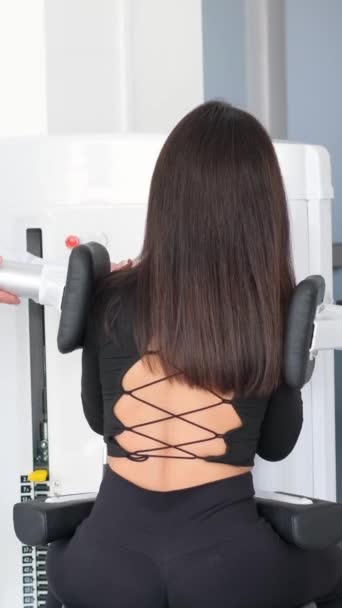 一位年轻妇女正在与理疗师一起在一台诊断机器上做脊柱检查 骨质疏松症 椎间盘突出 椎间盘突出 垂直录像 — 图库视频影像