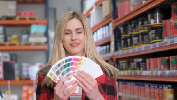 Una Joven Rubia Elige Colores Pintura Pinceles Una Ferretería Una — Vídeo de stock