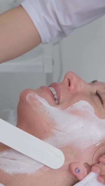 Kosmetolog Nakłada Maskę Nawilżającą Twarz Klienta Podczas Zabiegu Pielęgnacji Skóry — Wideo stockowe
