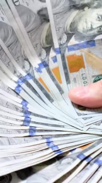许多100美元的钞票在一个蓝色背景的男人手里 垂直录像 — 图库视频影像
