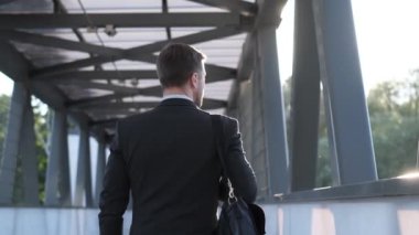 Müdür gün ışığının tadını çıkarıyor ve şehir sokaklarında yürüyor. Doğal ışık ile güzel bir çekim. Dikey video.