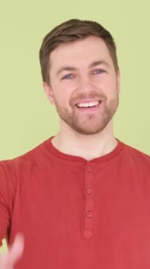 Avustralyalı adam onay veriyor, bir anlaşma işareti. Yeşil arka planda yakışıklı bir adam el hareketi gösterir. Dikey video