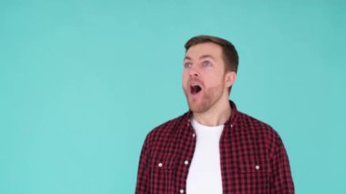 Şok olmuş Avrupalı, vay canına diyor. Mavi arka planda yakışıklı bir adam izlenim gösterir. Dikey video