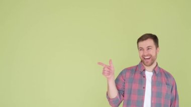 Sakallı, yeşil arka planda parmak gösteren Avrupalı bir adam. Metin reklamları için yer