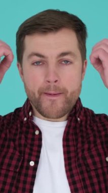 Şok olmuş bir adam stüdyoda izole edilmiş. İnsanların yaşam tarzı konsepti. Bir jest olarak kafaya el kaldırıyorum. Dikey video