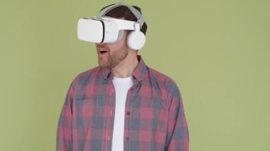 Sanal gerçeklik gözlüğü kullanan bir adam çevrimiçi öğrenme için üç boyutlu bir menü seçer. Dijital oyun simülatörü. Dikey video