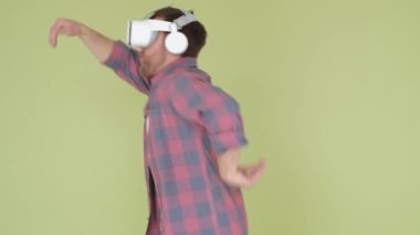 Bir adam sanal gerçeklik kaskı kullanarak dans ediyor. Teknolojik ilerleme. Üç boyutlu sanal gerçeklik gözlükleri. Dikey video