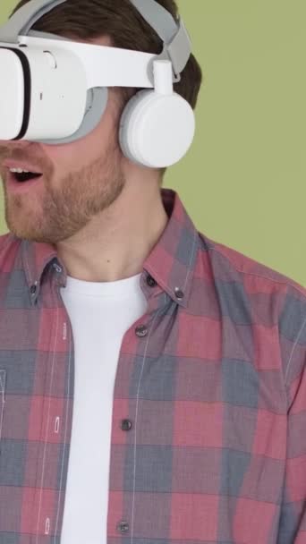 一个使用虚拟现实眼镜的男人选择一个3D菜单进行在线学习 数字游戏模拟器 垂直录像 — 图库视频影像