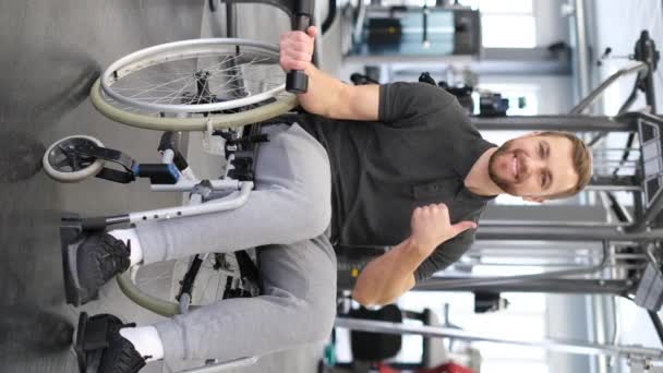 一个坐在轮椅上的男子在康复期间在健身房锻炼的垂直录像 残疾人的意志力 垂直录像 — 图库视频影像