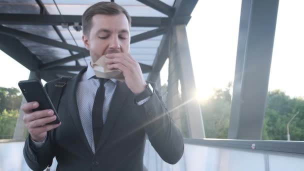 Empresário Meia Idade Está Comendo Hambúrguer Lendo Uma Mensagem Smartphone — Vídeo de Stock