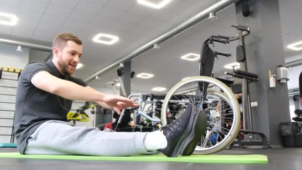 Tekerlekli Sandalyedeki Bir Adam Terapi Jimnastiği Yapıyor Yaralanmadan Sonra Rehabilitasyon — Stok video