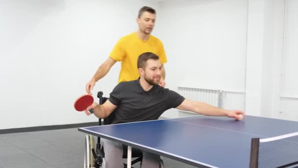 リハビリテーション医は車椅子の人と仕事をする 卓球ゲーム — ストック動画