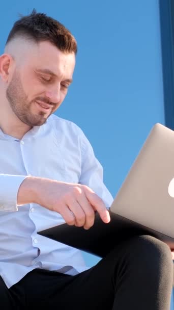 Homem Bonito Está Sentado Fora Perto Centro Escritório Trabalhando Laptop — Vídeo de Stock