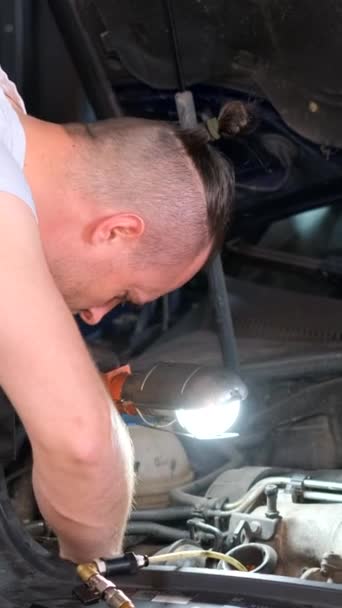 一个专业的汽车修理工在汽车站更换发动机的机油 现代设备上的机油自动更换 更换汽车中的过滤器 垂直录像 — 图库视频影像