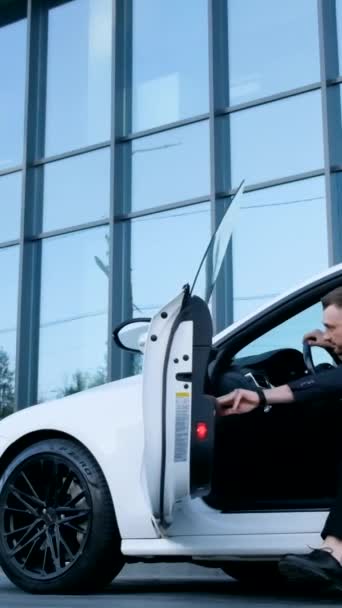 若いビジネスマンが白い車から出てきます スーパースローモーション 240フレーム バーティカルビデオ — ストック動画