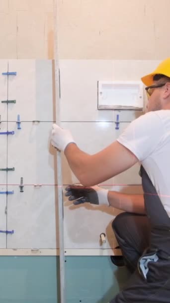 Egy Biztonsági Sisakos Építész Ellenőrzi Fürdőszoba Csempéinek Egyenletességét Egy Építőmunkás — Stock videók