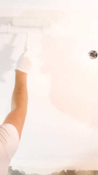 Homem Pinta Parede Branco Com Rolo Concept Builder Artista Capacete — Vídeo de Stock