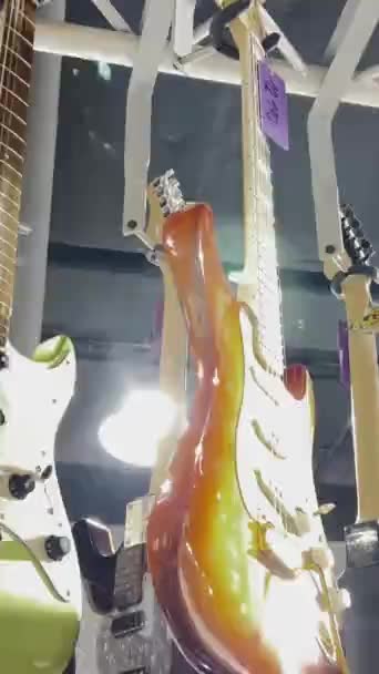 许多新的电吉他在一家音乐商店的内部 弦乐乐器 垂直录像 — 图库视频影像